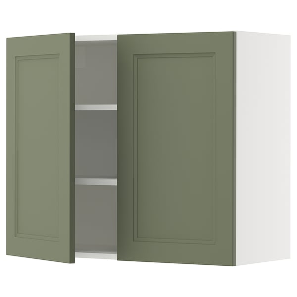 A green kitchen cabinet with one open door revealing shelves.