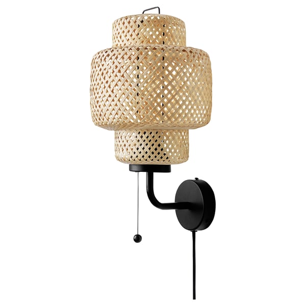SINNERLIG bamboo wall lamp with black base, soft glow.