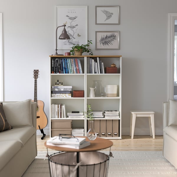 Cosy living room with SKRUVBY bookcase. Light wood, modern design, filled with books, surrounded by comfortable furniture.
