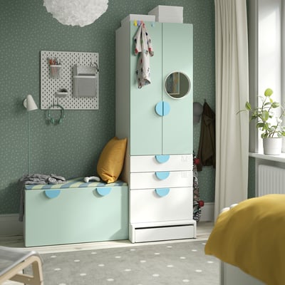 Kids room with SMÅSTAD light blue/white furniture: wardrobe, drawers, bench, mirror, & plant.