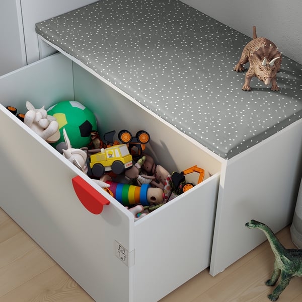Childrens storage unit with toys. White bin, grey lid, stuffed animals, and toys.