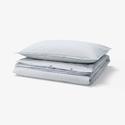A SOLFIBBLA duvet set with blue and white stripes, folded and stacked. Its made of soft cotton.
