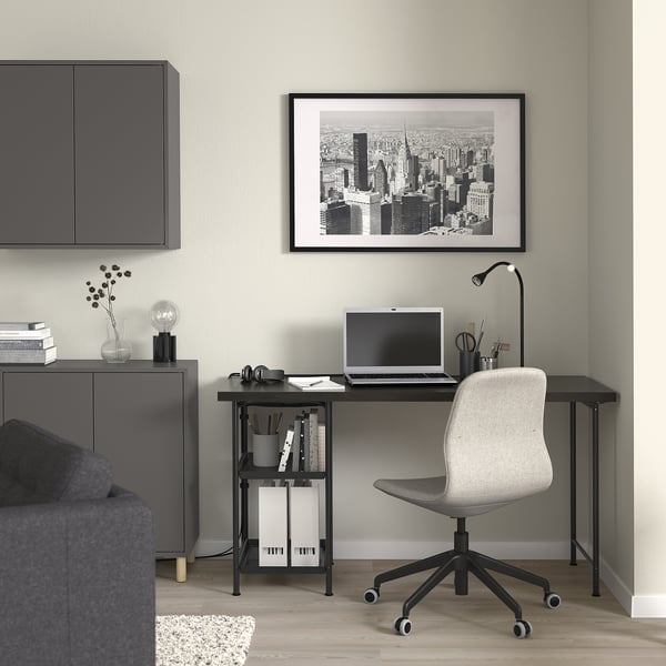 Modern home office with SPÄND desk, grey chair, cityscape, laptop, and sofa.