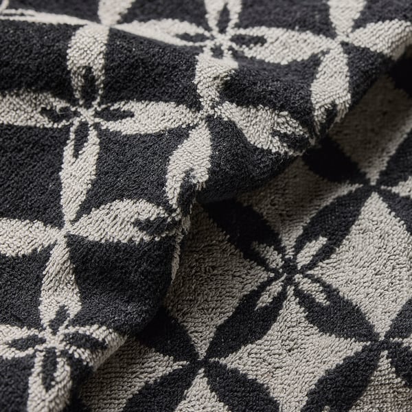 Black and white patterned throw blanket with intricate designs, showcasing detailed craftsmanship.