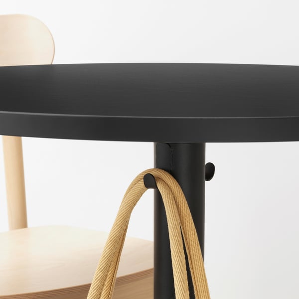 Modern round café table with hooks underneath for accessories.