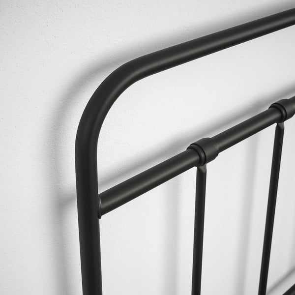 Close-up of a modern black metal bed frame headboard, showcasing its sleek design and quality construction.