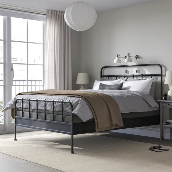 Modern grey bedroom with large STJÄRNÖ bed, metallic frame, white walls & large windows.