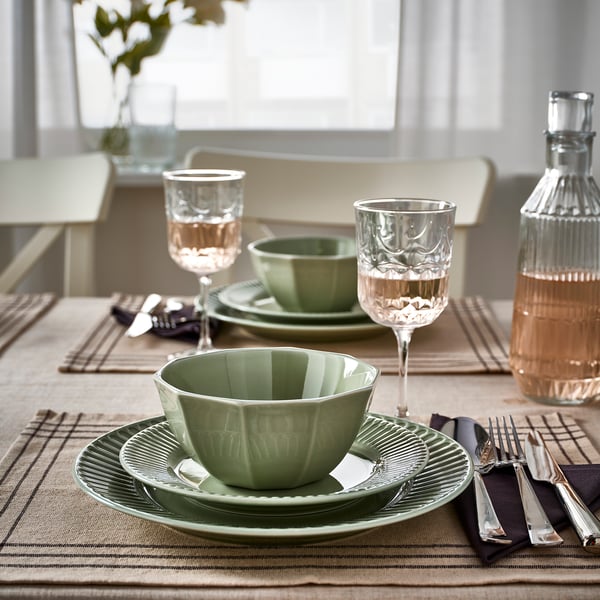 Green STRIMMIG porcelain set - plates, bowls, glasses, carafe, light background.