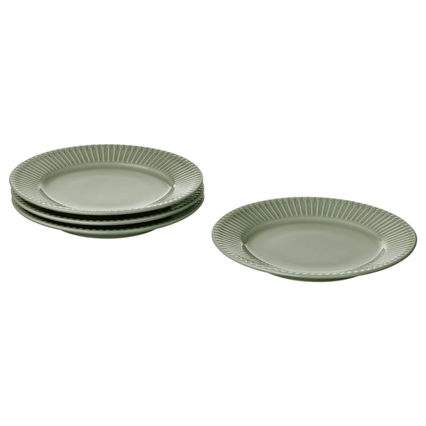 Four light green plates, three stacked, one flat, textured rim, ceramic.