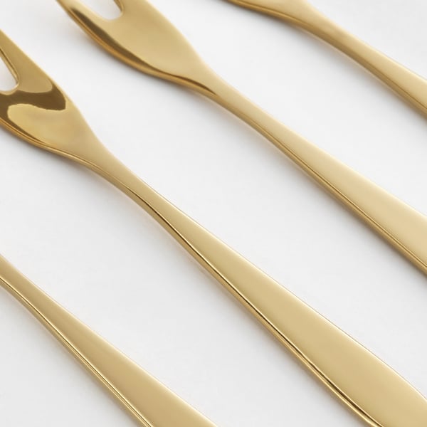 Gold-colored forks laid diagonally, reflecting polished, elegant quality.