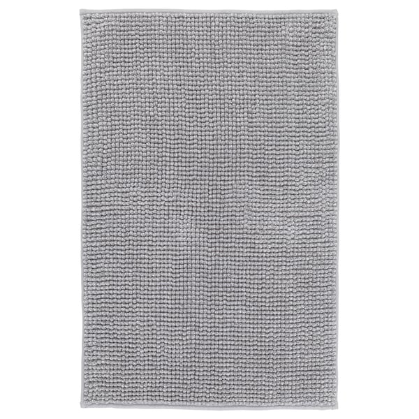A grey TOFTBO bath mat, rectangular, with a soft, textured design. It is made from recycled polyester.