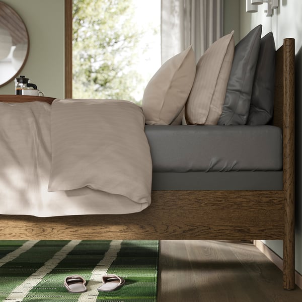 Bed frame with adjustable sides, lyngör base for extra height, sturdy, brushed veneer finish, slippers on rug.
