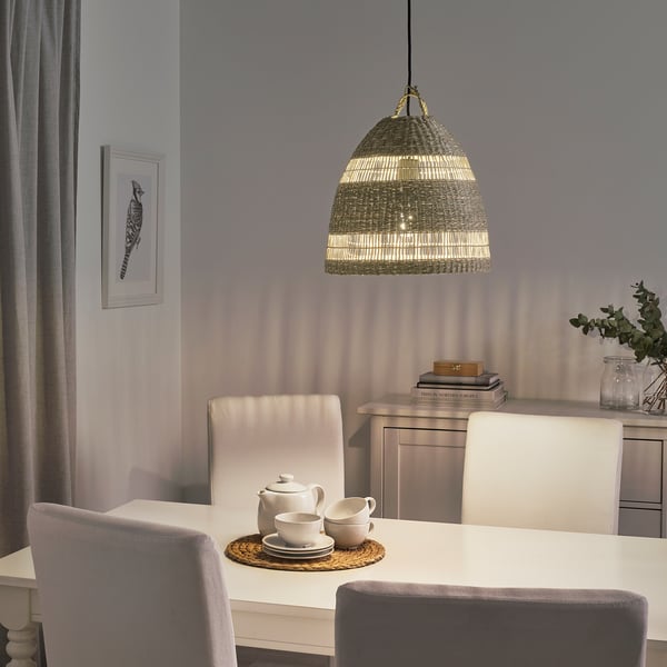 TORARED pendant lamp made of sedge, warm light, hangs above dining table with tea set, decorative shadows, hand-braided, large size.