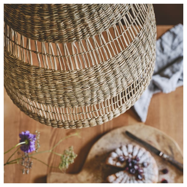 Unique hanging lamp, TORARED, golden with woven sedge texture. Casts warm glow, perfect for rustic decor.