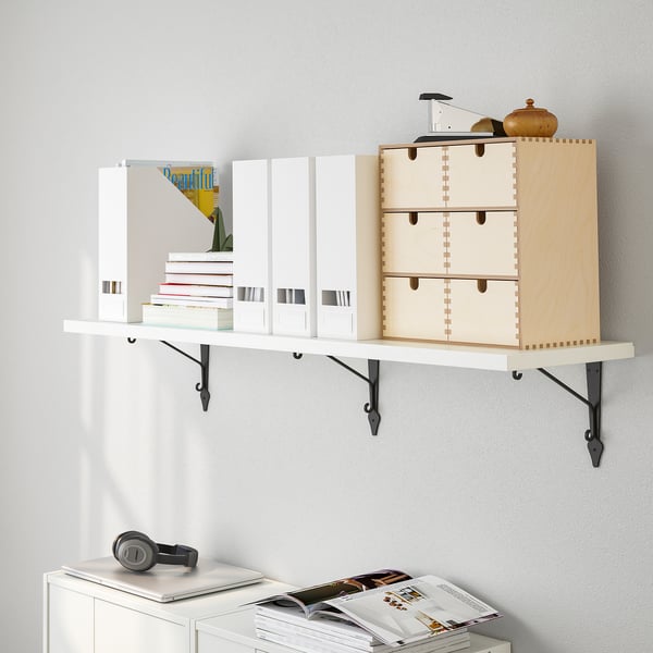 Wall-mounted shelf displaying books, a wooden box, and decorative items. Efficiently organises and items on a white wall.