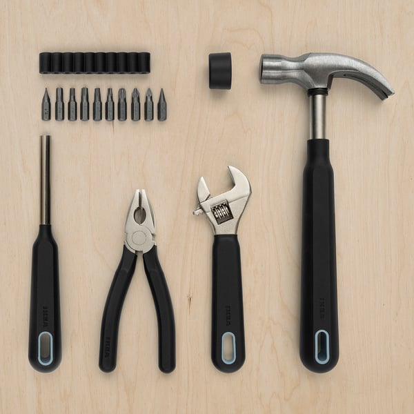 TRIXIG tool set: includes black pliers, wrench, screwdrivers, and hammer with rubber grip, neatly arranged on wood, ideal for diy projects.