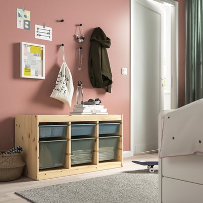 TROFAST storage with mesh boxes near door, skateboard, basket, and art on wall.