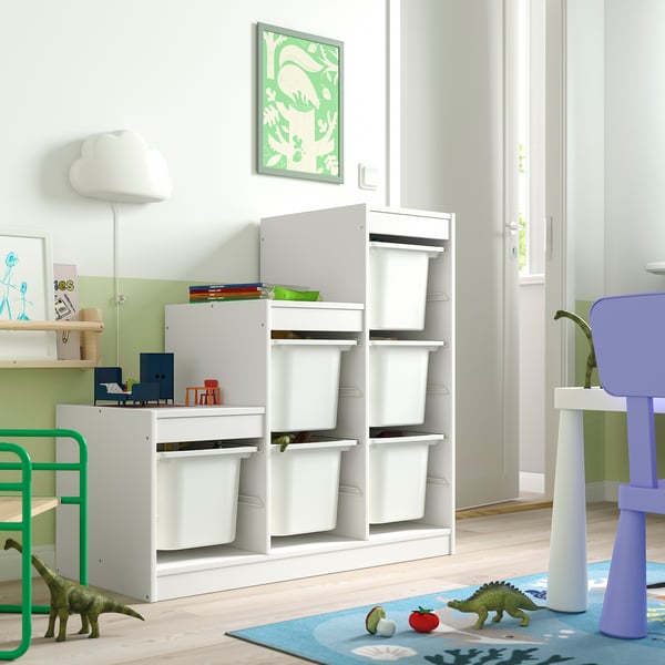 Kids playroom with TROFAST storage, bins, shelves, toys, dinosaur theme, blue rug, green wall, dinosaur poster.