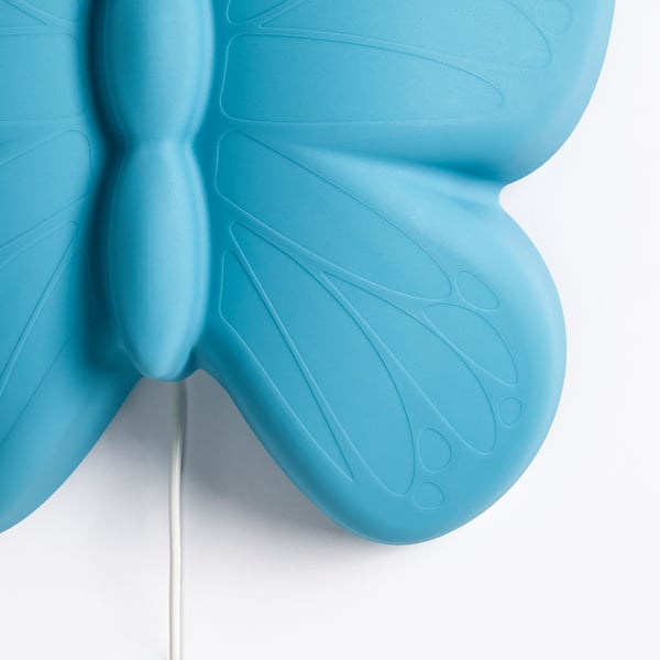 A close-up of a blue, textured butterfly-shaped childrens lamp, showcasing its smooth, detailed design and playful aesthetic.