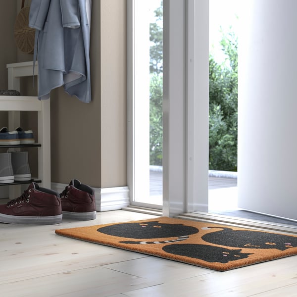 Brown & black cat door mat near entrance.
