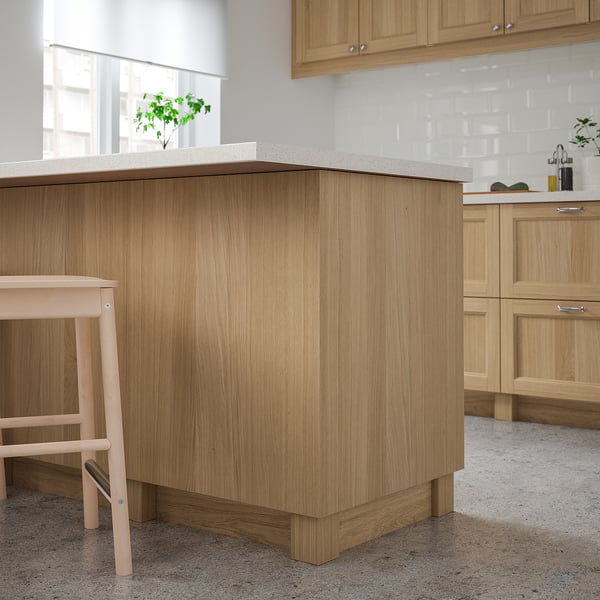 Kitchen with light oak VEDHAMN island & cabinets; sleek, natural wood design.