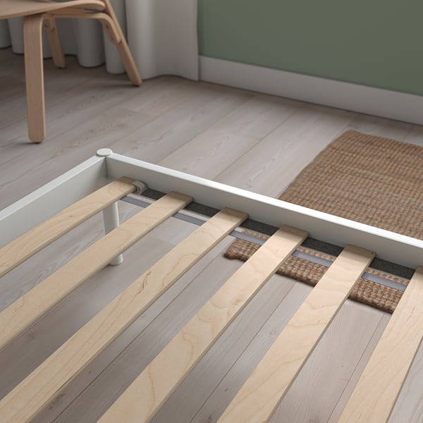 A modern white bed frame with wooden slats, designed for stability and space utilisation.
