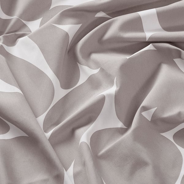 Patterned fabric with wavy curves in neutral tones. Soft, likely cotton, wrinkled texture visible.