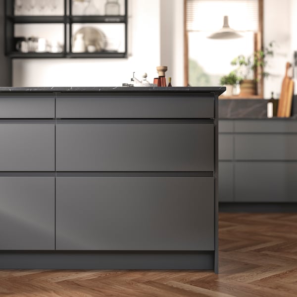 Modern grey kitchen island with sleek, dark grey drawers and a black countertop, featuring minimalist design.