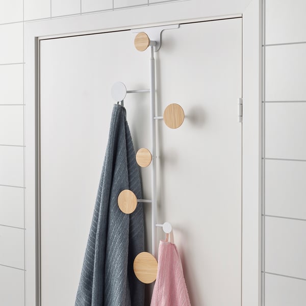 Adjustable door hanger with wooden knobs holds towels and clothes, mounted vertically on a door.