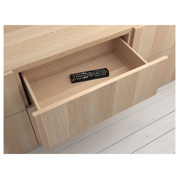 Wooden drawer with remote, part of BESTÅ storage system.