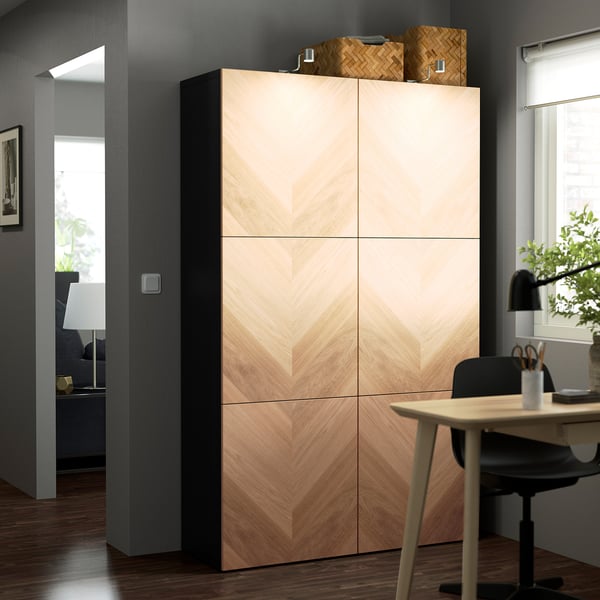 Wooden BESTÅ cabinet with chevron patterns, next to a desk, with baskets.