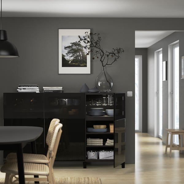 Modern dining room with BESTÅ sideboard, glass doors, & decor.