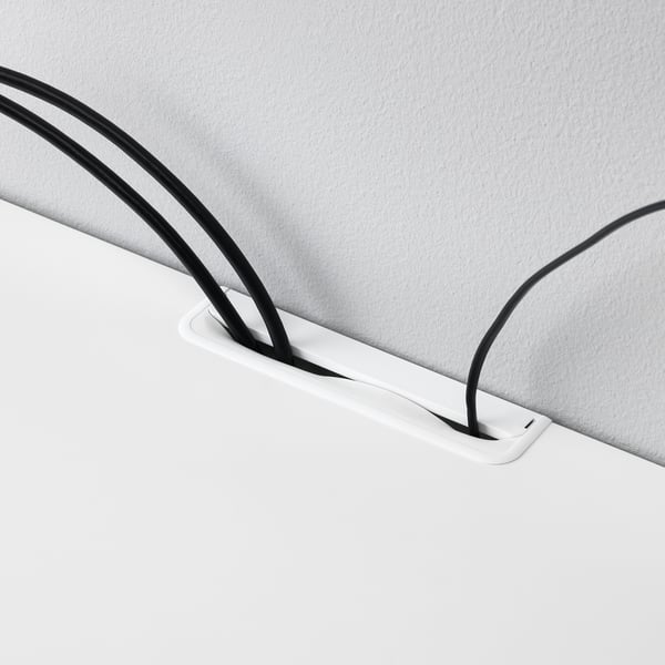 Cord organiser beneath desk, managing cables for tidy setup.