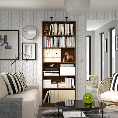 Living room with BILLY bookcase, sofa, coffee table, wicker chair, and modern decor.