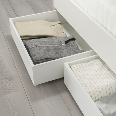 Two open storage boxes under bed for bedding, easy to access with castors.