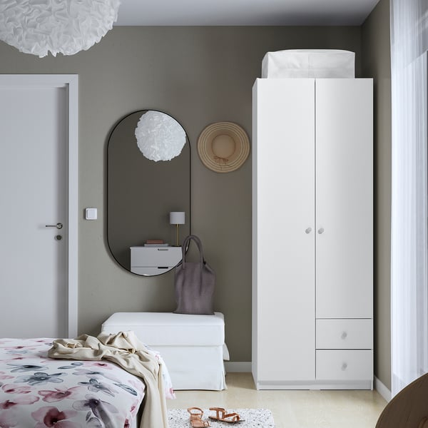 Modern bedroom with BRUKSVARA wardrobe, mirror, floral bed, minimalist decor.