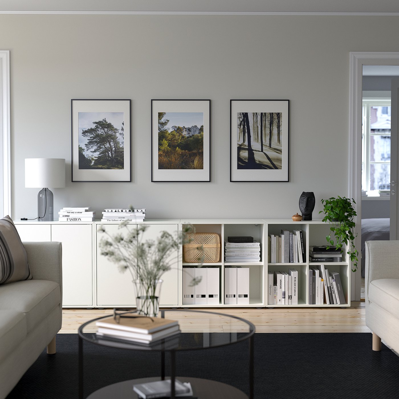 Modern living room with EKET storage, sofas, and glass coffee table.