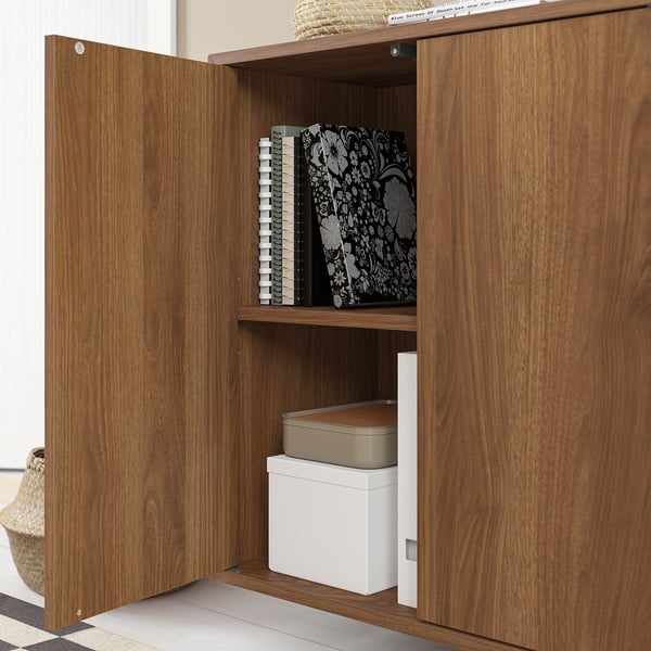 Wooden cabinet with open door, storing books and boxes.