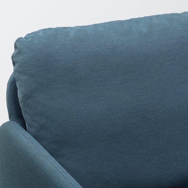 Plush, vibrant blue sofa close-up, showcasing comfortable, plush cushions with sleek lines.