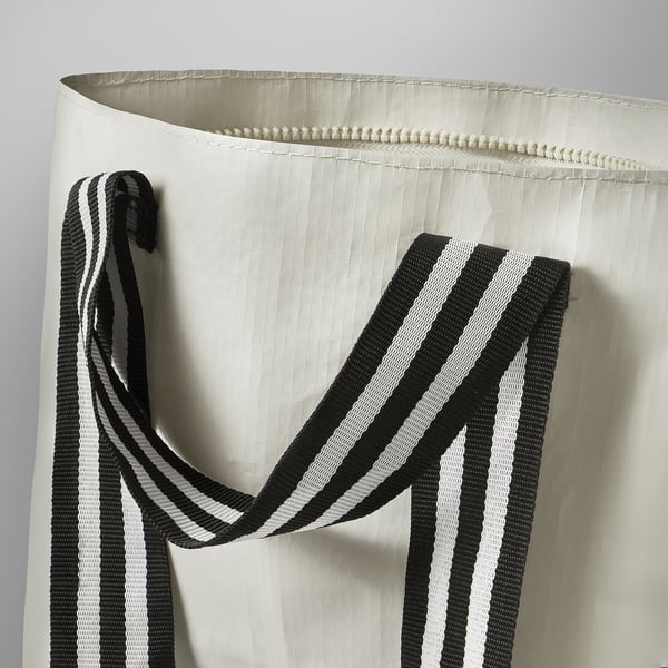 Close-up of sturdy, black and white striped handle on durable white bag.