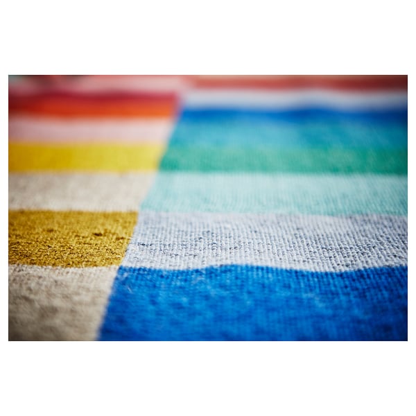 HALVED rug close-up, stripes blue, white, yellow, red, woven wool.
