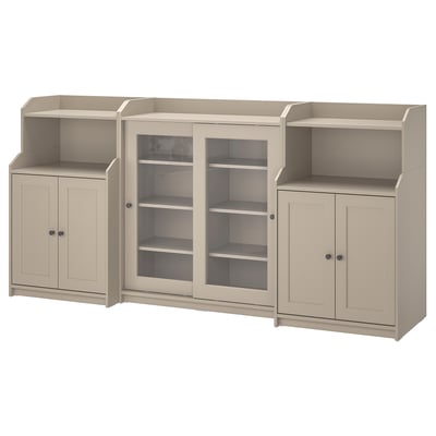 Light beige HAUGA storage unit with glass doors and cabinets. Modern design with open and closed storage. Ensure safety with wall attachment.