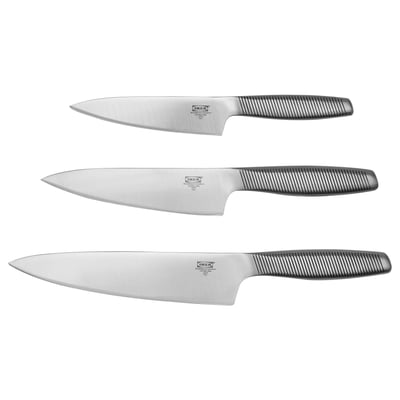 Three stainless steel ikea knives with grey handles, arranged vertically, sharp blades visible.