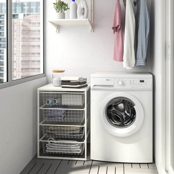White JONAXEL storage next to washing machine with shelves and baskets.