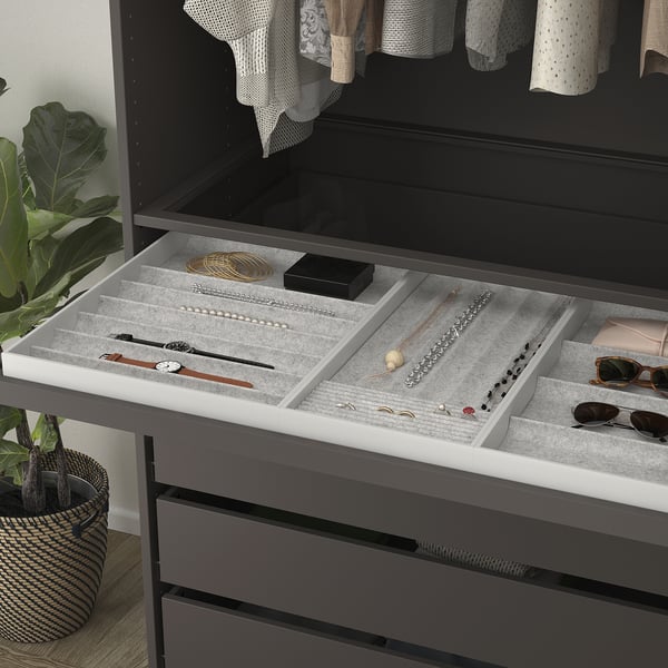 Jewellery organiser tray with compartments for necklaces, rings, and watches in opened drawer.