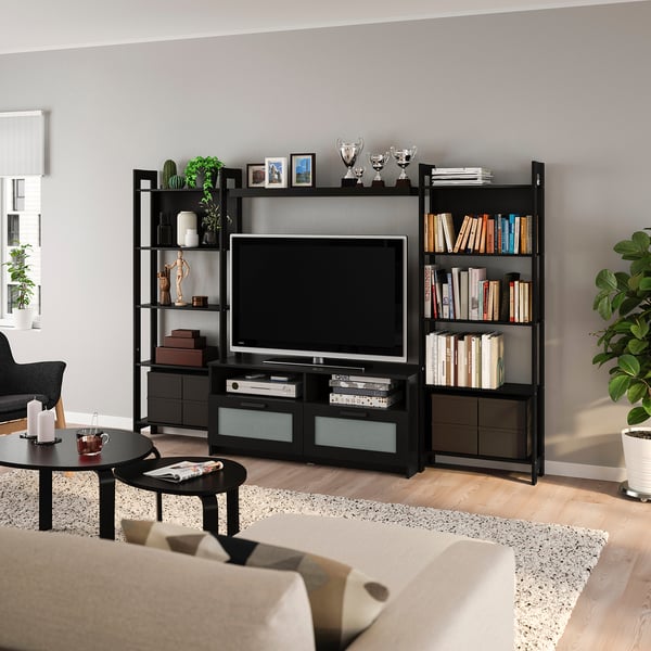 Modern living room with black LAIVA media unit, tv, books, decor, and coffee table. Beige sofa nearby.
