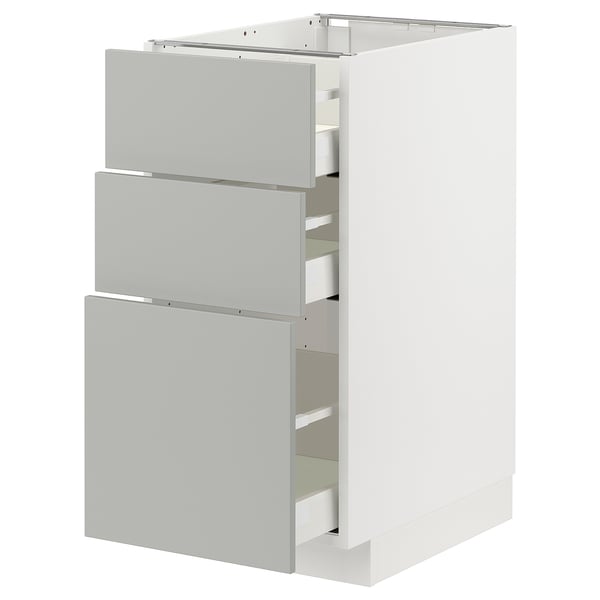 A white METOD kitchen cabinet with light grey drawers, featuring a modern and clean design.
