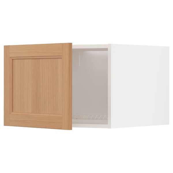 Light wood cabinet door opens to white fridge/freezer top.