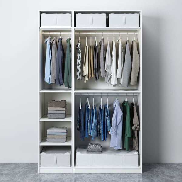 Modern white wardrobe with clothing hangers, folded clothes, and storage bins, designed for organised space.