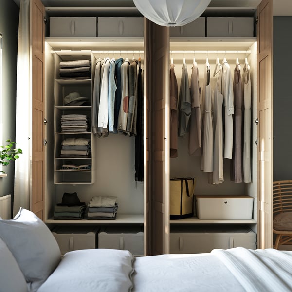 Open wardrobe showcasing organised clothes and accessories with shelves, racks, and storage boxes.
